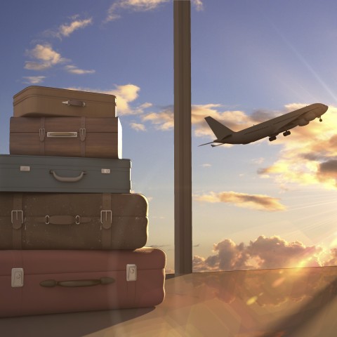 Suitcases Stacked by an Airport Window, with a Plane Taking Off in the Background.