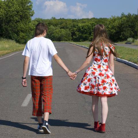 A Couple Walking Down the Street Holding Hands