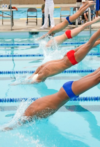 Swimmers diving into pool