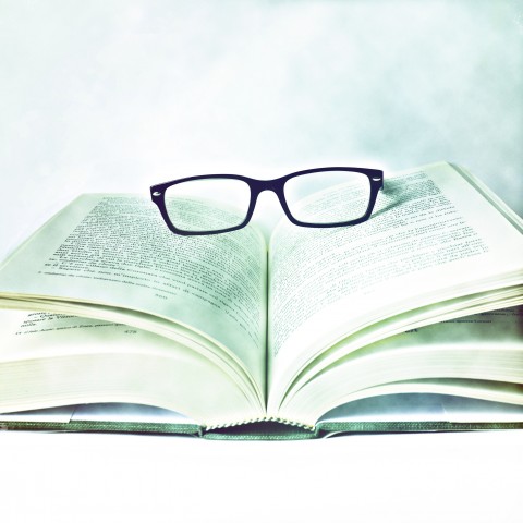 A Pair of Glasses on Top of an Open Book