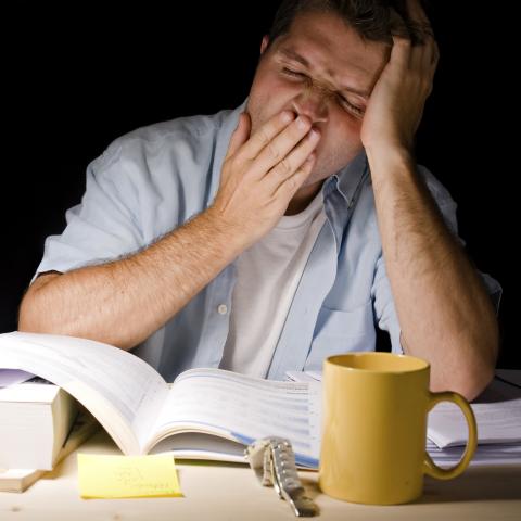 A Man Yawning While Working Llate at Night