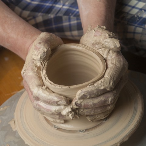 someone forming a pottery bowl