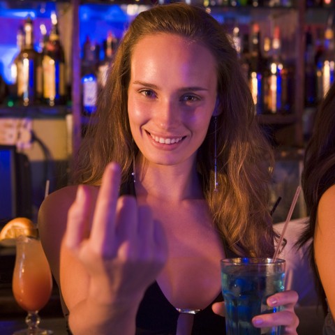 A Woman in a Bar Gesturing for Someone to Come Over