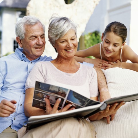 Grandparents with Granddaughter Going through Photo Album