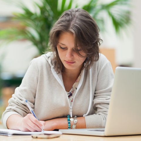 A Woman Taking Notes while Studying