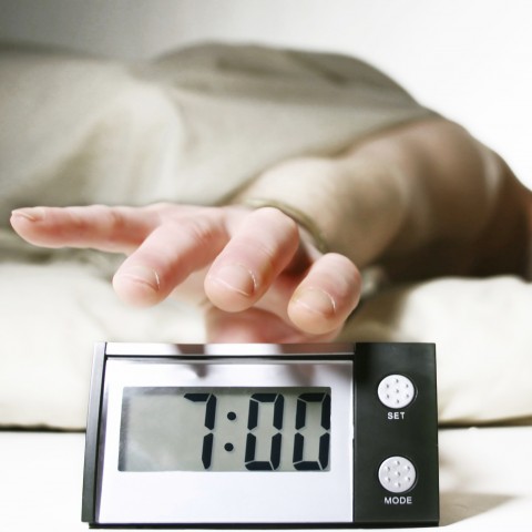 A Hand Reaching for An Alarm Clock