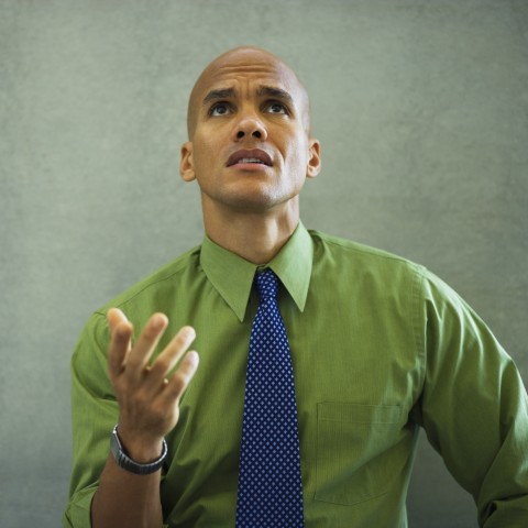 A Bald Man Wearing a Tie and a Watch Looking Up at Someone