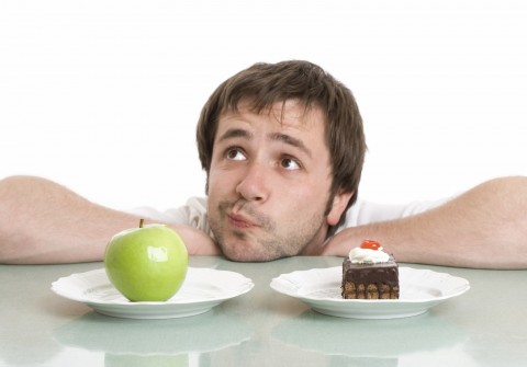 A Man Trying to Decide between an Apple or Cake