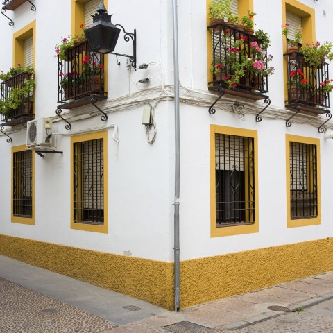 A white and yellow building on the corner of two streets