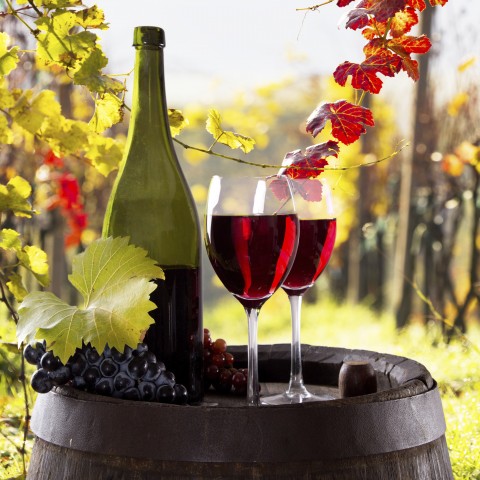 Wine and Grapes on Top of a Barrel