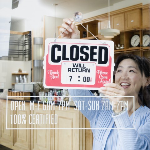 Woman in a shop, adjusting the shop sign