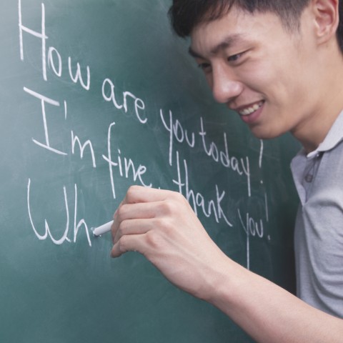 A Person Writing English Sentences on the Blackboard