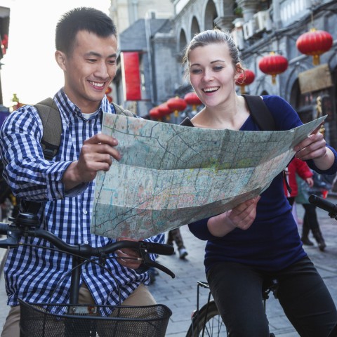 A Guy and a Girl Looking at a Map Smiling
