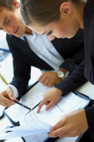 Two people reviewing paperwork together at a desk