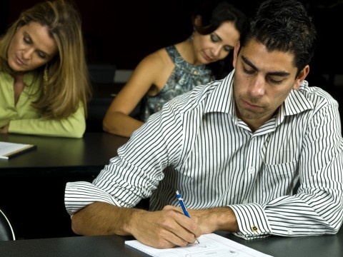 A Group of Students Testing in a Dark Classroom