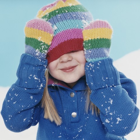 A Smiling Little Girl Hides Under Her Hat.