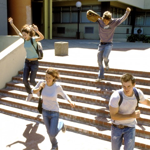 Jubilant Students Running Down the Stairs on Campus.