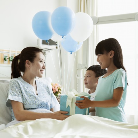 Une femme à l'Hôpital Qui reçoit la visite de Ses enfants