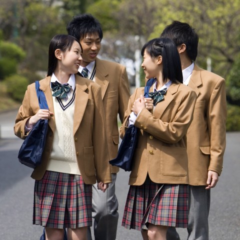  Four Japanese High School Students Are Walking Together and Talking