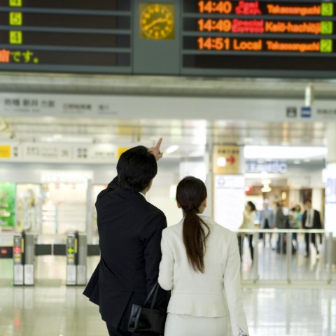 Two People Looking at the Train Schedule