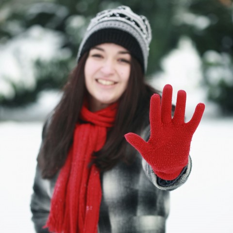 A Girl in Winter Clothes Raising Her Hand to the Camera Indicating She Doesn't Want to be Photographed