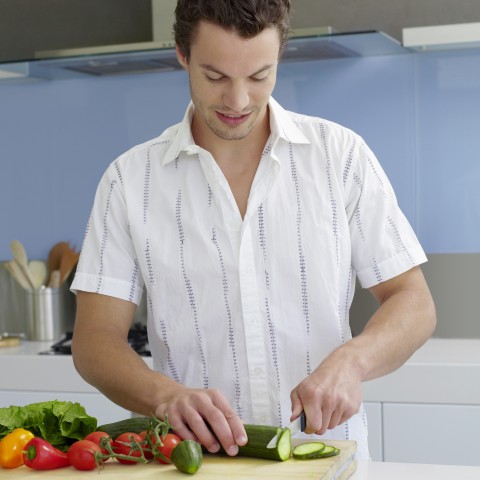 A Man Chopping Vegetables in the Kitchen