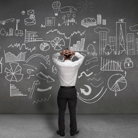 A Man Staring at a Busy Blackboard in Confusion