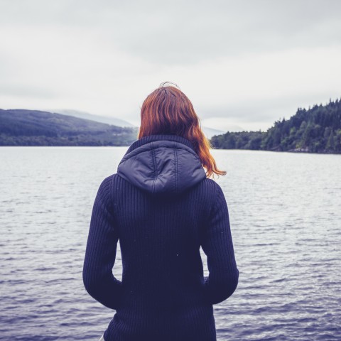 A Woman Looking Out at a Body of Water