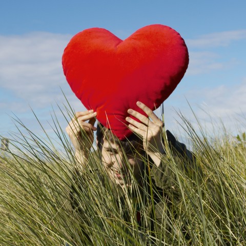 A Boy Holding a Heart-shaped Cushion