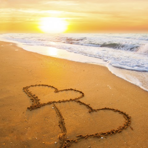 A Beach with a Pair of Hearts Drawn in the Sand.