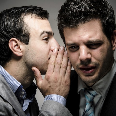 One Businessman Whispering Something in the Ear of Another Businessman