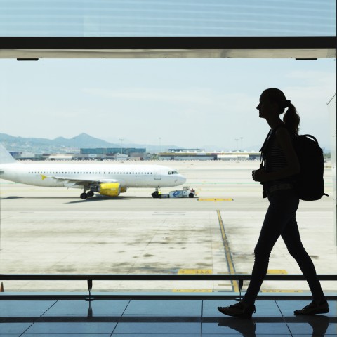 An Airplane and a Silhouette of a Woman in Front of a Window