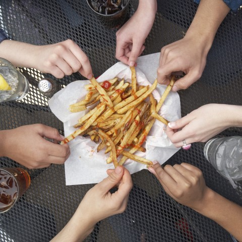 Seven people sharing french fries