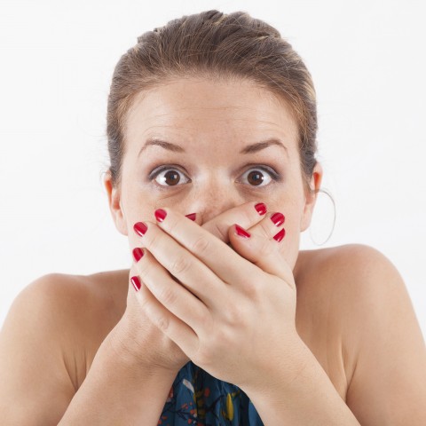 A Woman Shutting Her Mouth with Both Hands