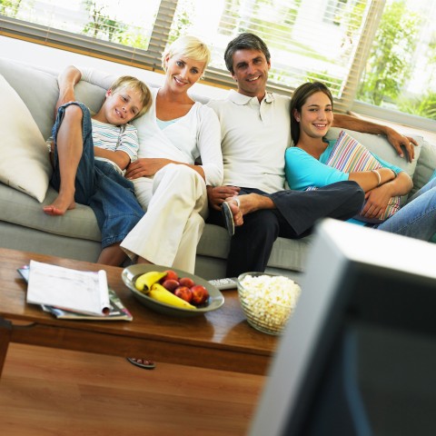 Family of Four Watching TV Together on the Couch