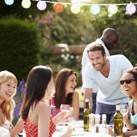 A Group of Friends Eating Outdoors Together with Drinks