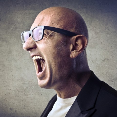 A Bald Man with Glasses Yelling at Someone