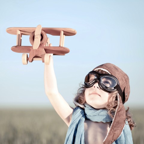 BOY HOLDING A TOY AIRPLANE