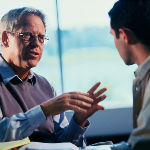 A Man in Casual Clothes Explaining Something to Another Man