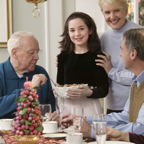 A Family Having Dinner; Granddaughter, Grandma, and Grandpa Are Seen Around the Table