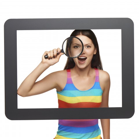 A Woman Looking through an Eyeglass while Standing behind a Frame