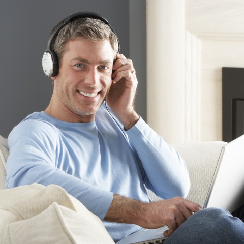 Smiling Young Guy with Blue Sweater, Sitting with Headphones On