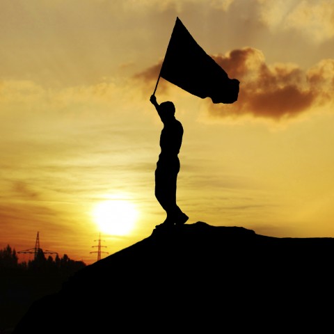 Silhouette of Person Carrying Flag