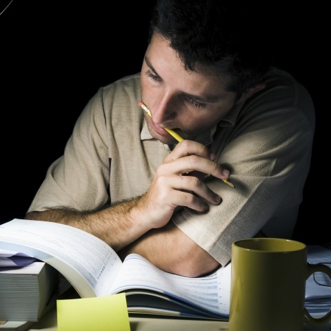 A man studying under the dim light.