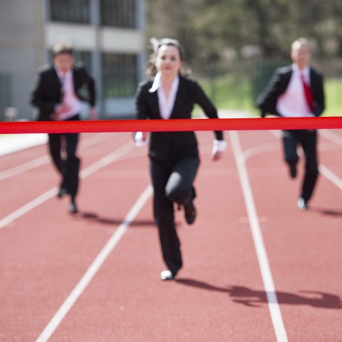 One Woman and Two Men in Suits Running and Competing in a Race