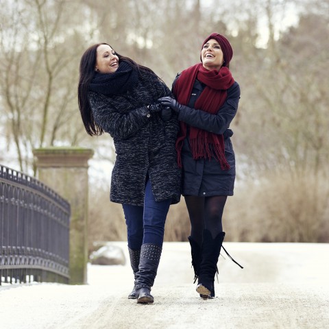 Two Young Women Walking Arm-in-arm in the Snow.