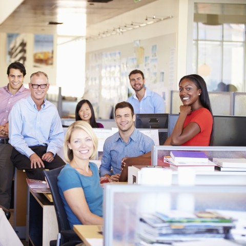 A Group of Colleagues in the Office Smiling for a Group Photo