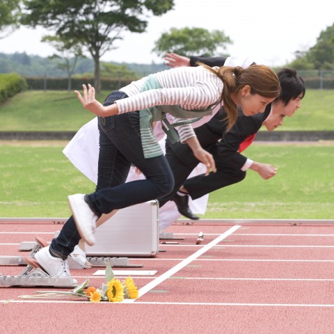 Group of people running on track field