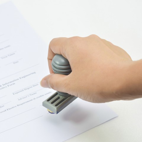 person stamping a paper