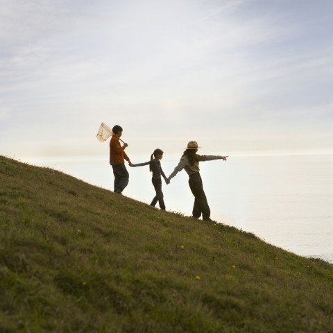 A Mother and Her Two Children Walking Down a Hill Together